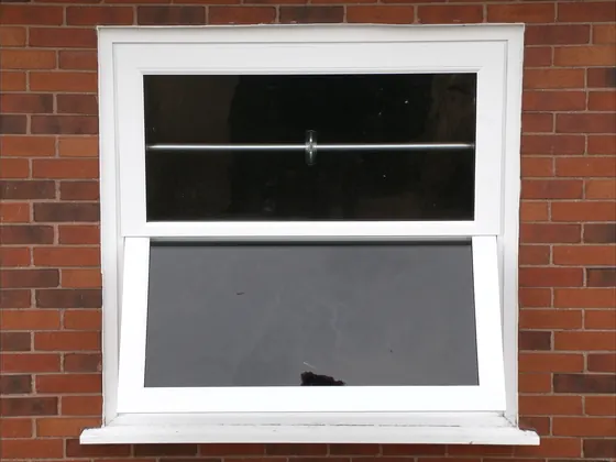 Double-hung window on a brick house with the lower sash raised